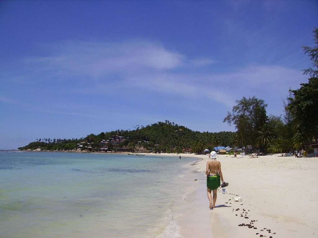 Person spaziert Strand entlang