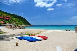 Weißer Strand mit Booten und Meer